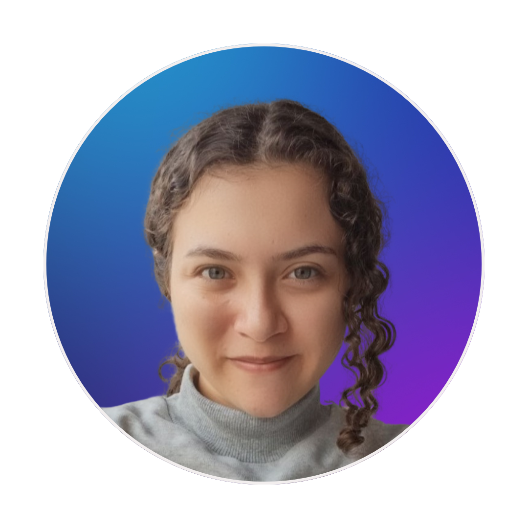 Foto de Regiana Cruz, uma mulher de cabelo castanho cacheado preso, vestindo um moletom cinza.